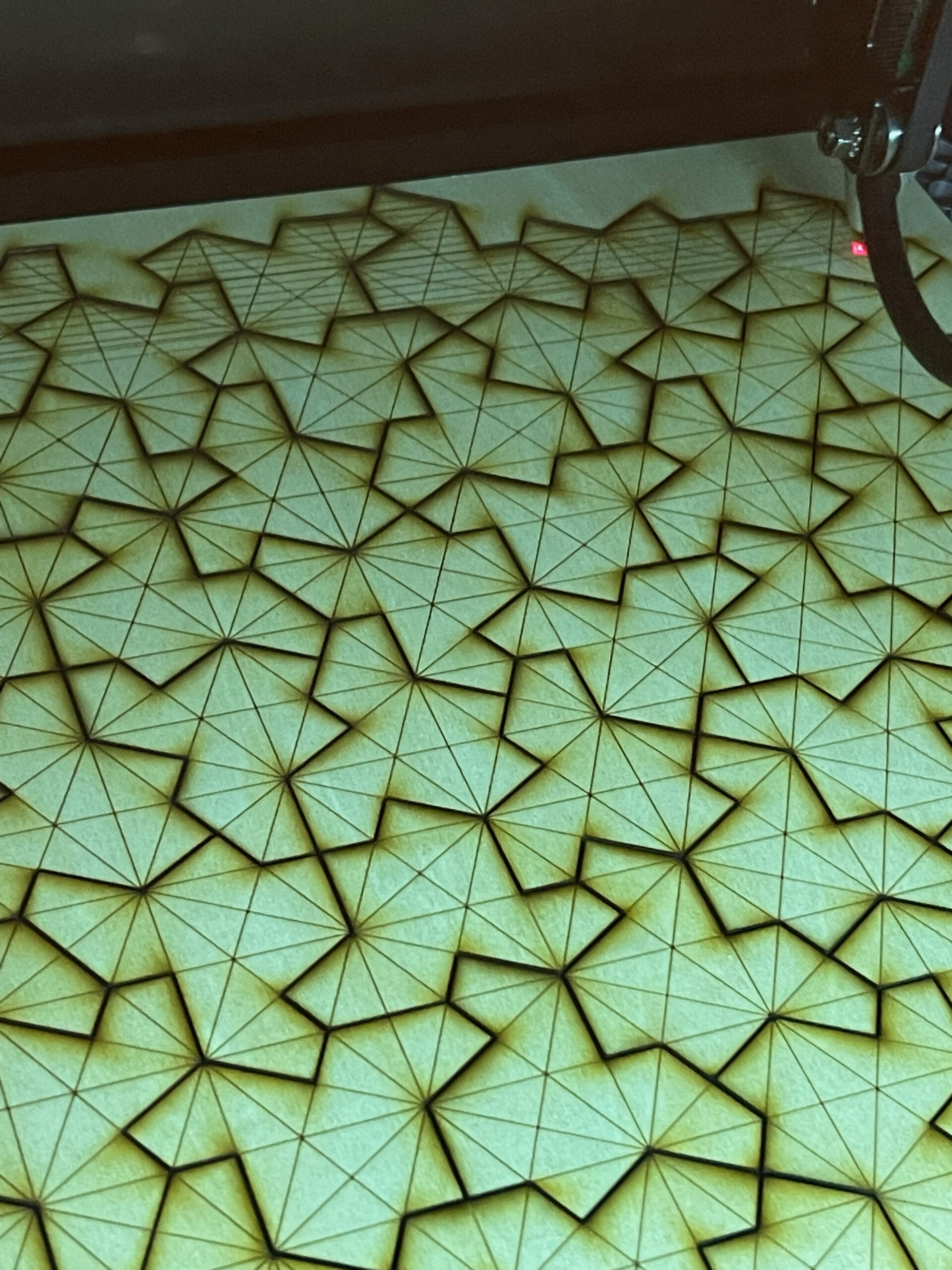 Close-up of laser-cut Einstein tiles on the cutting bed